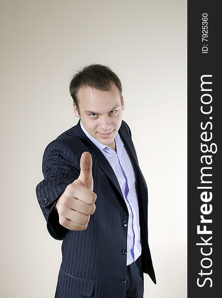 Young businessman showing thumbs up