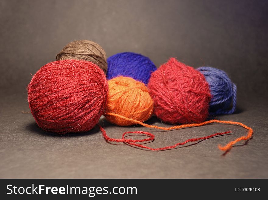 Coloured balls of threads on a black background