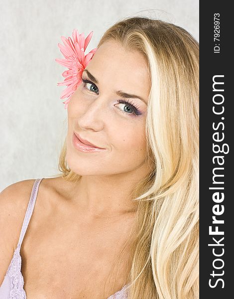 Blond girl with chrysanthemum in studio shot