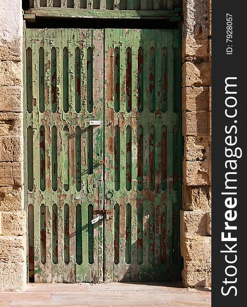 A neglected door with flaking green paint. A neglected door with flaking green paint