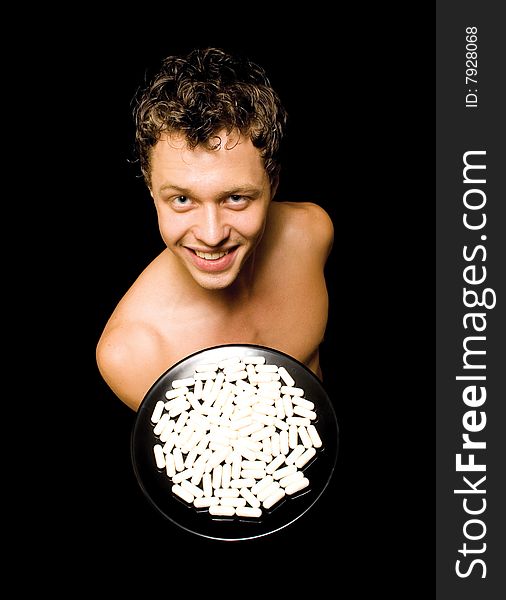 Muscular man showing medicine on an isolated black background. Muscular man showing medicine on an isolated black background