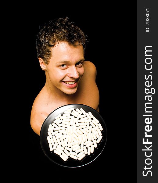 Man showing medicine on an isolated black backgrou