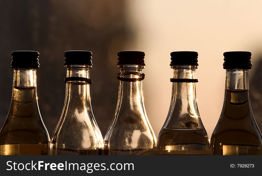 Five bottles near window at shiny evening