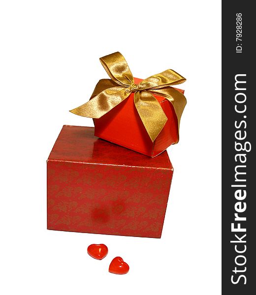 Two red gifts with a gold ribbon and two hearts isolated on a white background