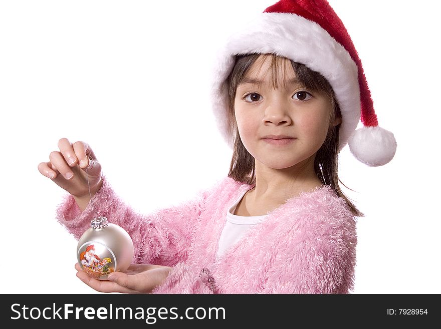 A girl with a santa hat holds a christmas ornament. A girl with a santa hat holds a christmas ornament.