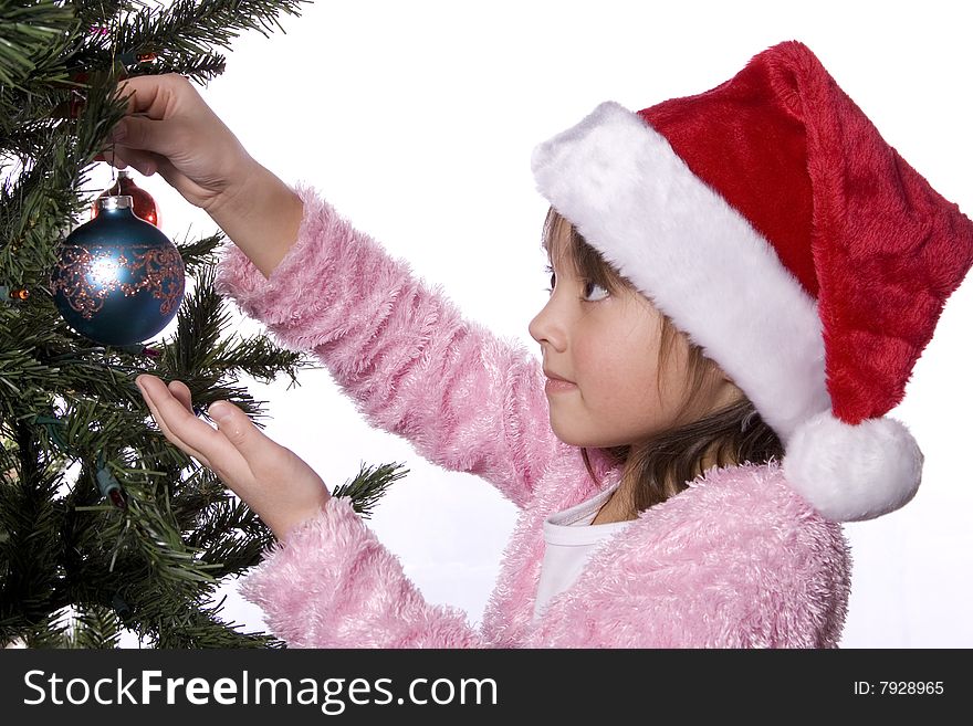 Girl Carefully Puts Ornament On Tree.