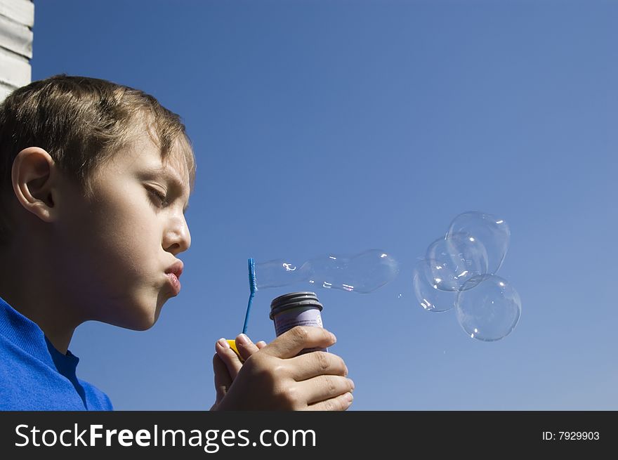 Boy blowing soap bubbles