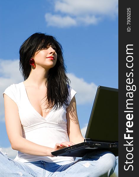 Pretty woman with laptop on sky background