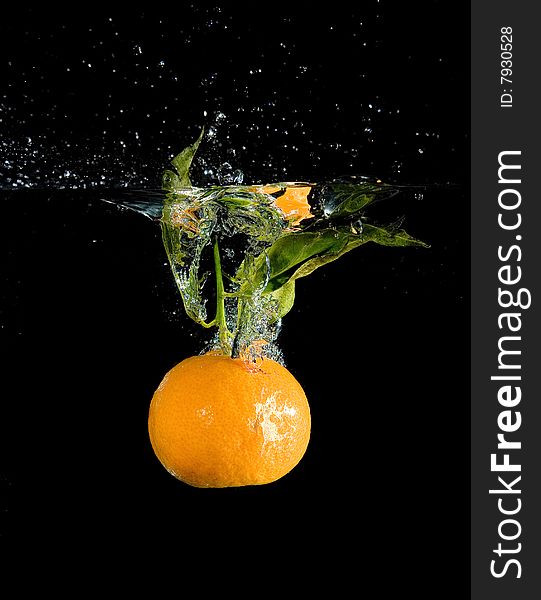 Tangerine in water with bubbles on black ground. Tangerine in water with bubbles on black ground