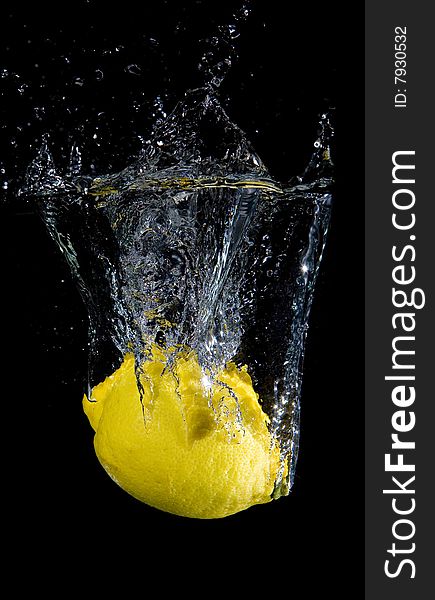 Lemon in water with bubbles on black ground. Lemon in water with bubbles on black ground