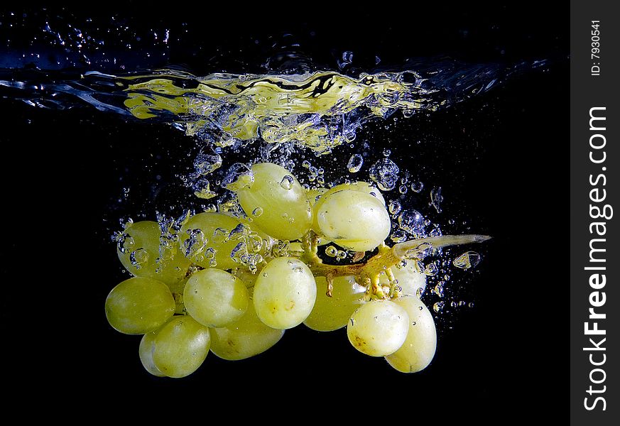 Grapes in water with bubbles on black ground. Grapes in water with bubbles on black ground