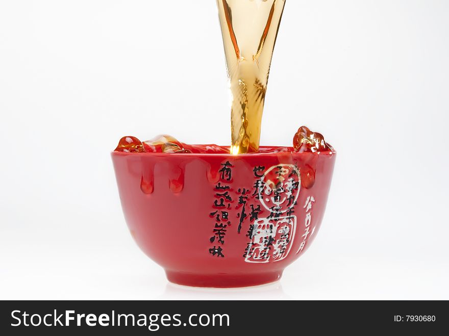 Pouring tea into chinese red teacup. Pouring tea into chinese red teacup