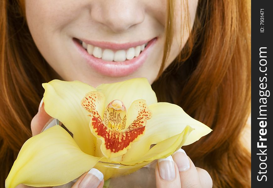 Close up of a orchid at girl's hands and her smile, focus on flower. Close up of a orchid at girl's hands and her smile, focus on flower