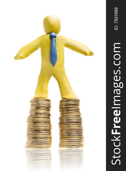 Plasticine businessman stands on two heaps of gold coins. Plasticine businessman stands on two heaps of gold coins