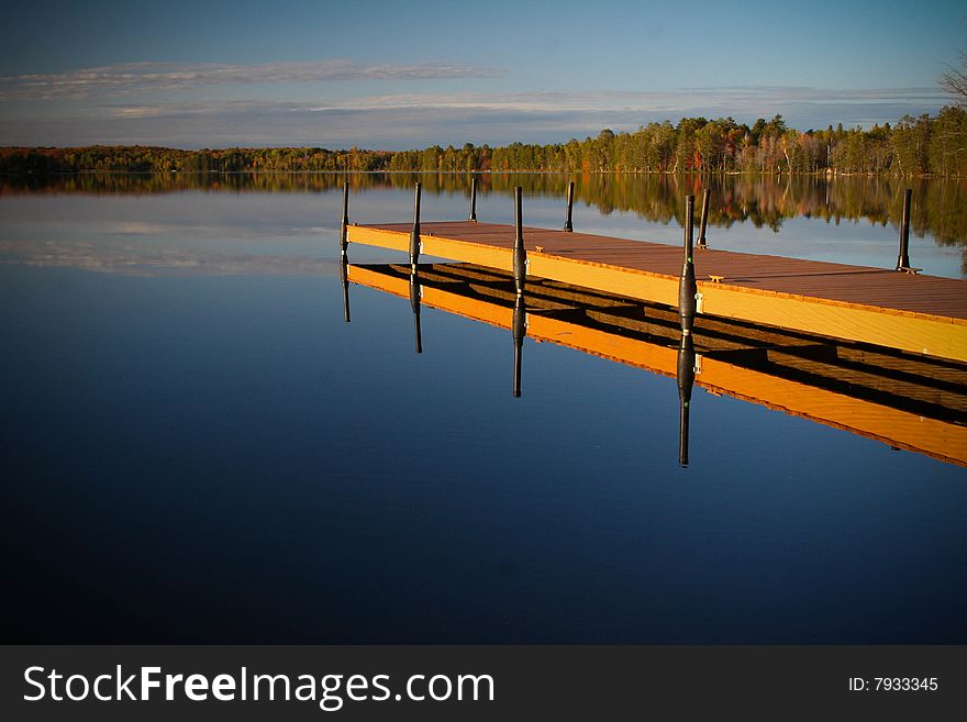 Calm lake view with dock in the foreground. Calm lake view with dock in the foreground