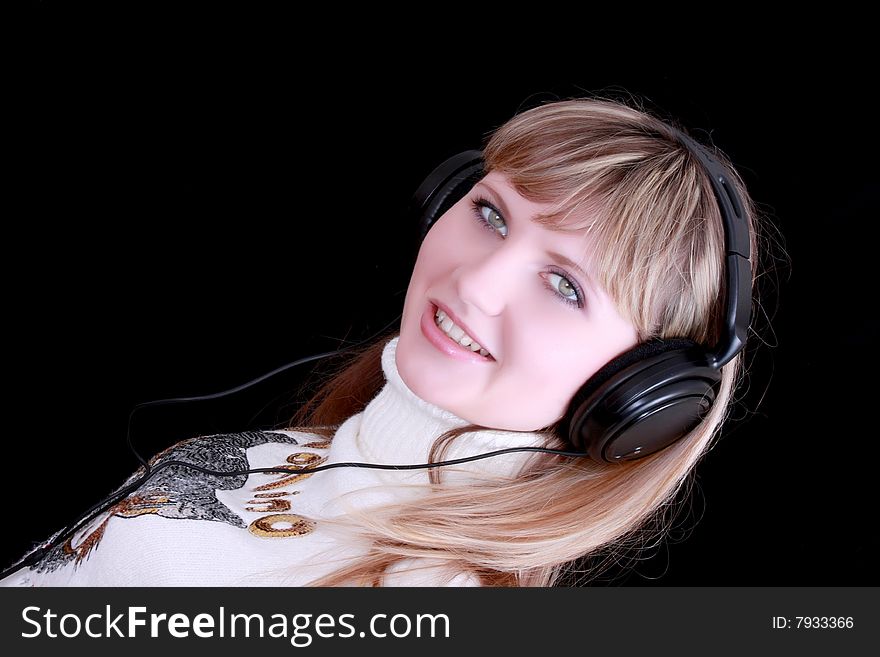 Young girl with headphones on black background