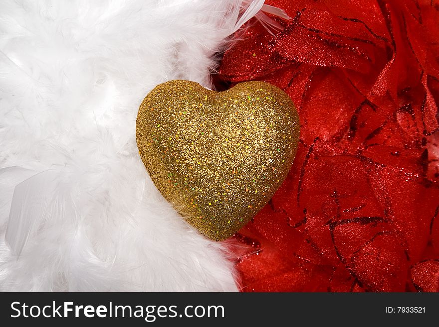 Golden heart over white and red feathers background