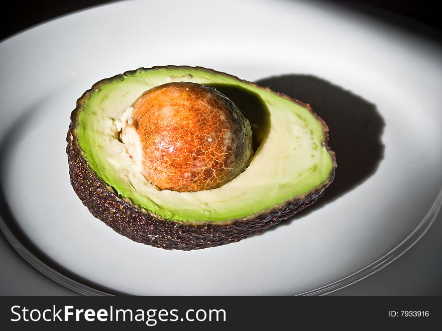 Textured Half Avocado On The White Plate