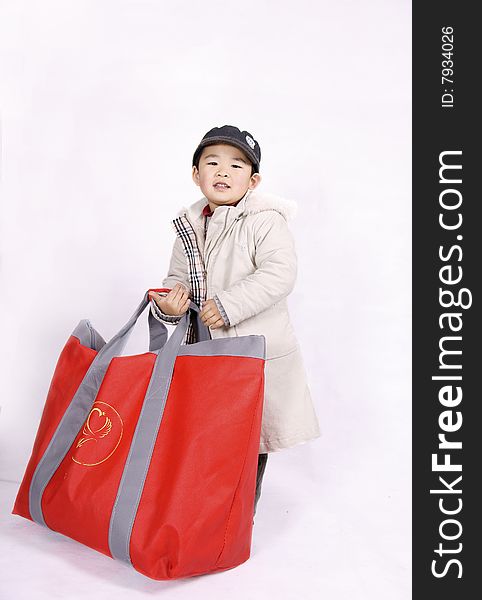 A picture of a pretty chinese boy going shopping carrying a big bag. A picture of a pretty chinese boy going shopping carrying a big bag