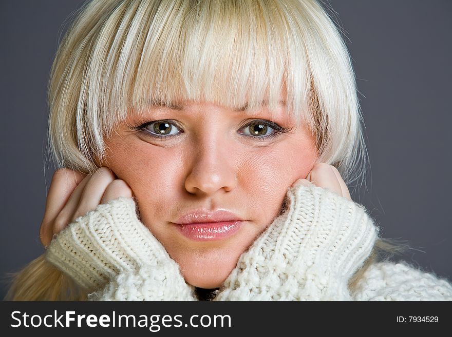 Lovely blond woman with a serious look on ones face indoors