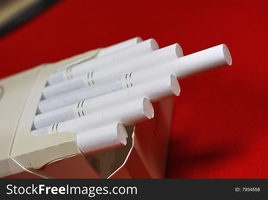 The opened pack of cigarettes on a red background