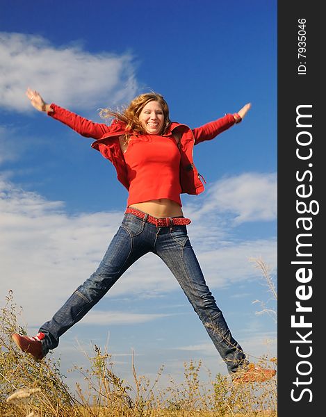 The girl jumps in the field against the sky. The girl jumps in the field against the sky