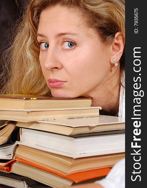 Young tired woman with a pile of books. Young tired woman with a pile of books