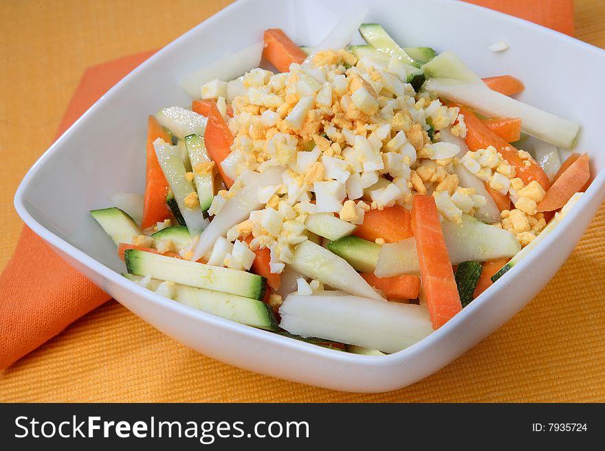 Boiled egg cubes with fresh vegetable on plate