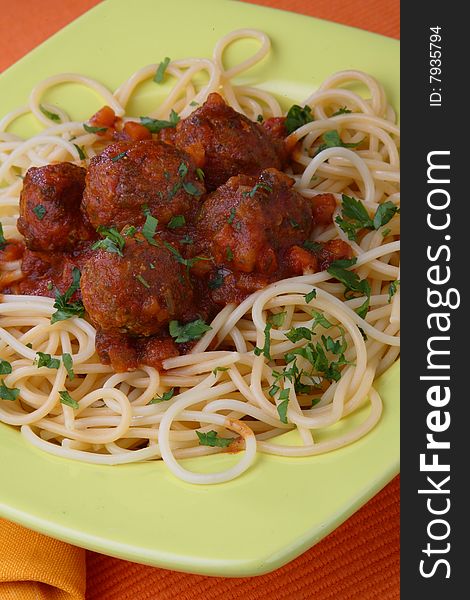 Turkey meat balls in sauce with spaghetti and herbs on plate