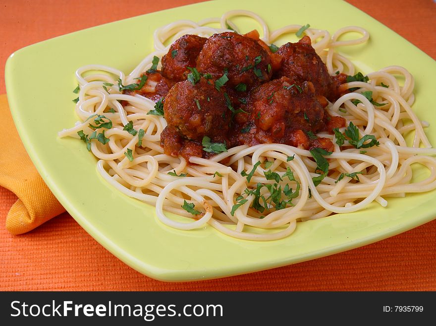 Turkey meat balls in sauce with spaghetti and herbs on plate