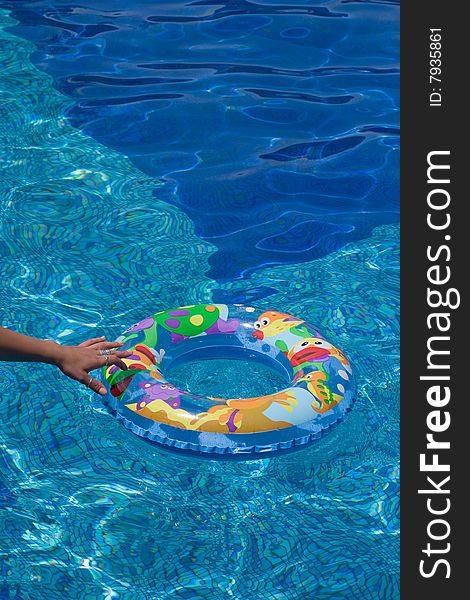 Rubber swimming ring floating in water while hand trying to reach it. Rubber swimming ring floating in water while hand trying to reach it