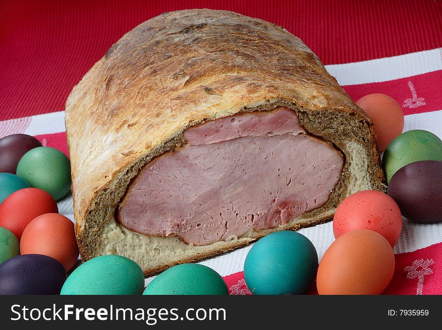 Easter ham on bread with colored eggs on plate