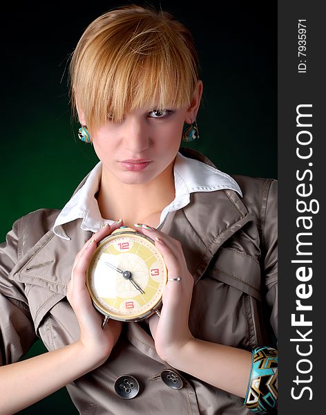 Beautiful woman with alarm clock on a black background