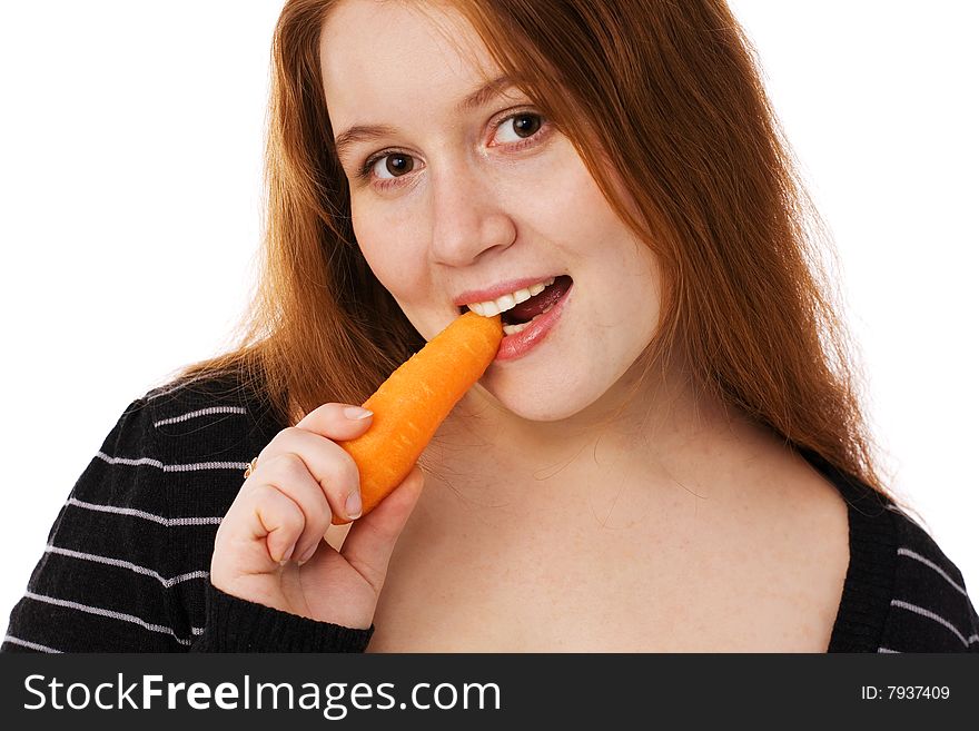 The young beautiful woman with long red hair eats a carrot. The young beautiful woman with long red hair eats a carrot