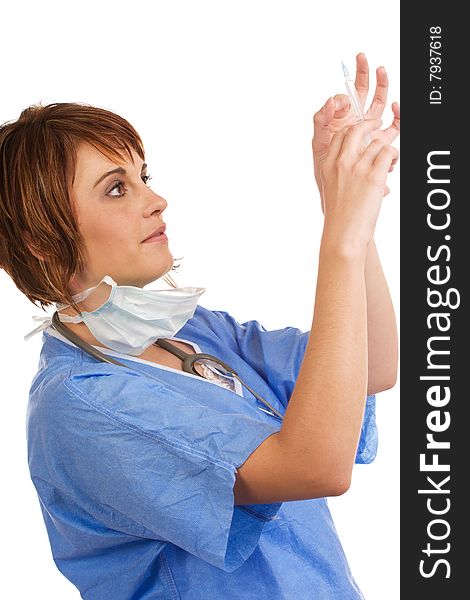 Attractive young female Caucasian doctor holding up and tapping a filled syringe to remove air bubbles. Attractive young female Caucasian doctor holding up and tapping a filled syringe to remove air bubbles