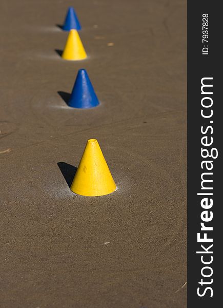 A closeup of yellow and blue skaters cones used to master skating skills. A closeup of yellow and blue skaters cones used to master skating skills