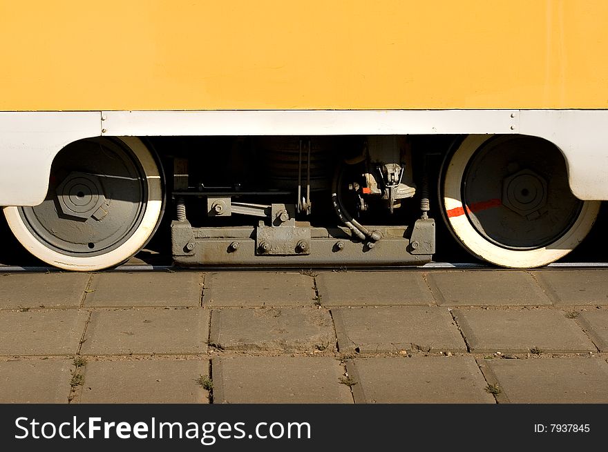 A closeup of yellow tram train wheels. A closeup of yellow tram train wheels