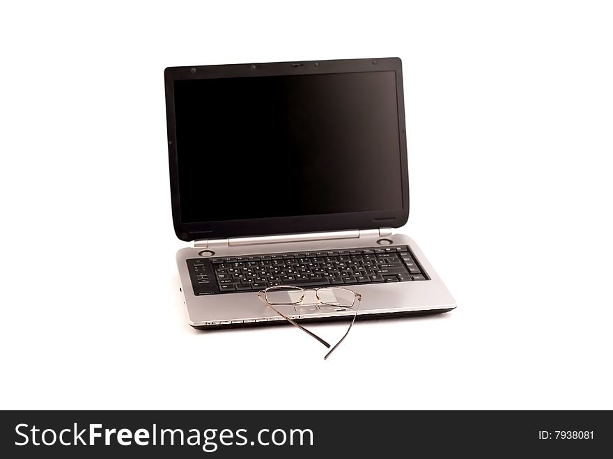 Laptop and glasses, widescreen display, a silver body, black keyboard, isolated object on a white background