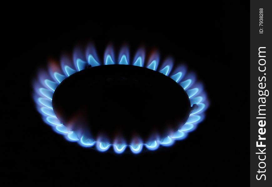 Blue flame of gas over black background