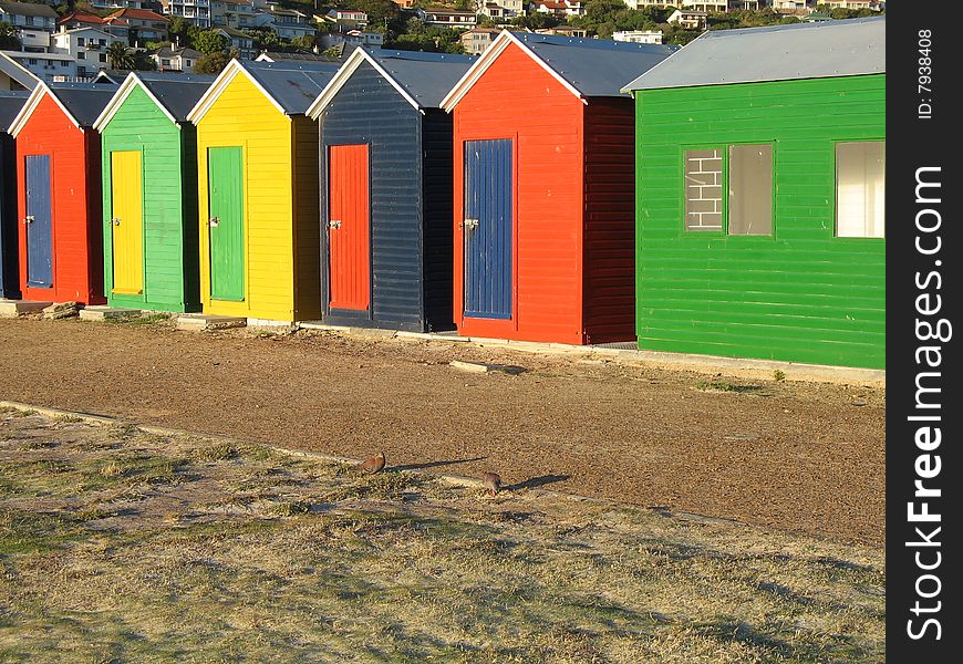 Brightly Coloured Beach huts with a mountain in the background