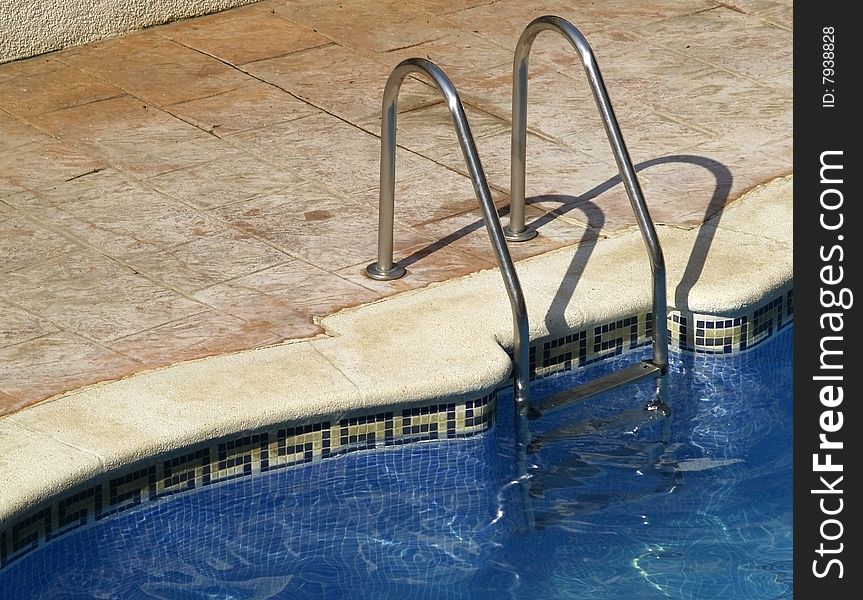 Swimming pool entrance with metal hand rail