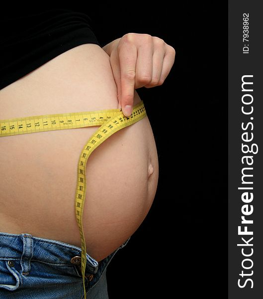 Pregnant woman measuring her big belly. Pregnant woman measuring her big belly