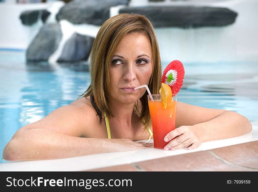 Beautiful Woman With Cocktail In A Swimming Pool