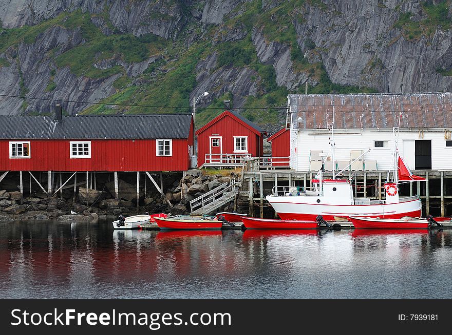 Small red and white wooden houses near the lake. Small red and white wooden houses near the lake