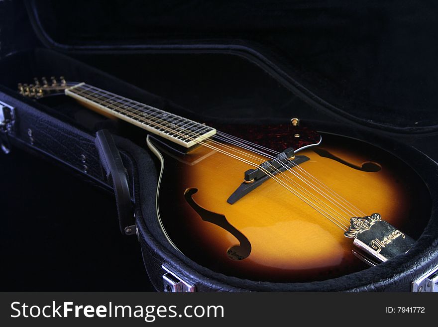 Mandolin, in leather case. A musical instrument isolated on black background. Mandolin, in leather case. A musical instrument isolated on black background