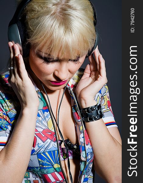 Lovely fashion woman listening music in headphones indoors