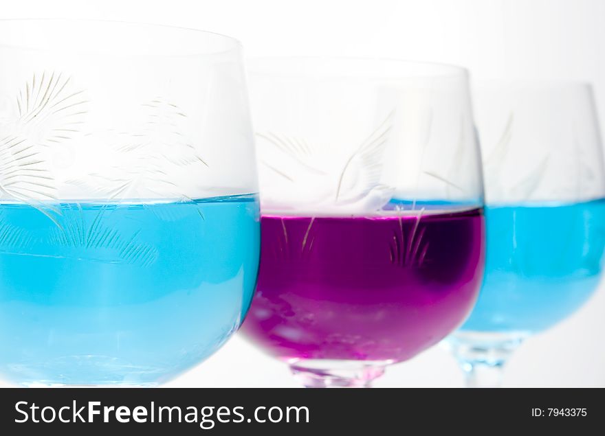 Three wineglass with drink blue and magenta colors