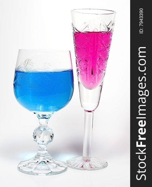 Two wineglass with drink blue and magenta colors
