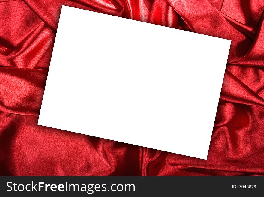 Blank white card on red colored satin cloth