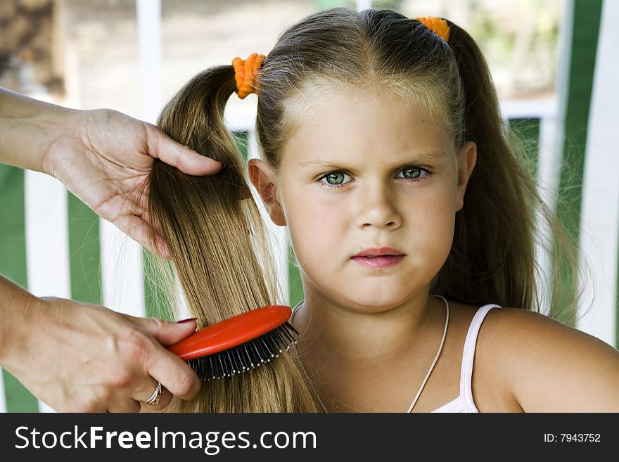 Little blond long hair girl has haircare by stylist.